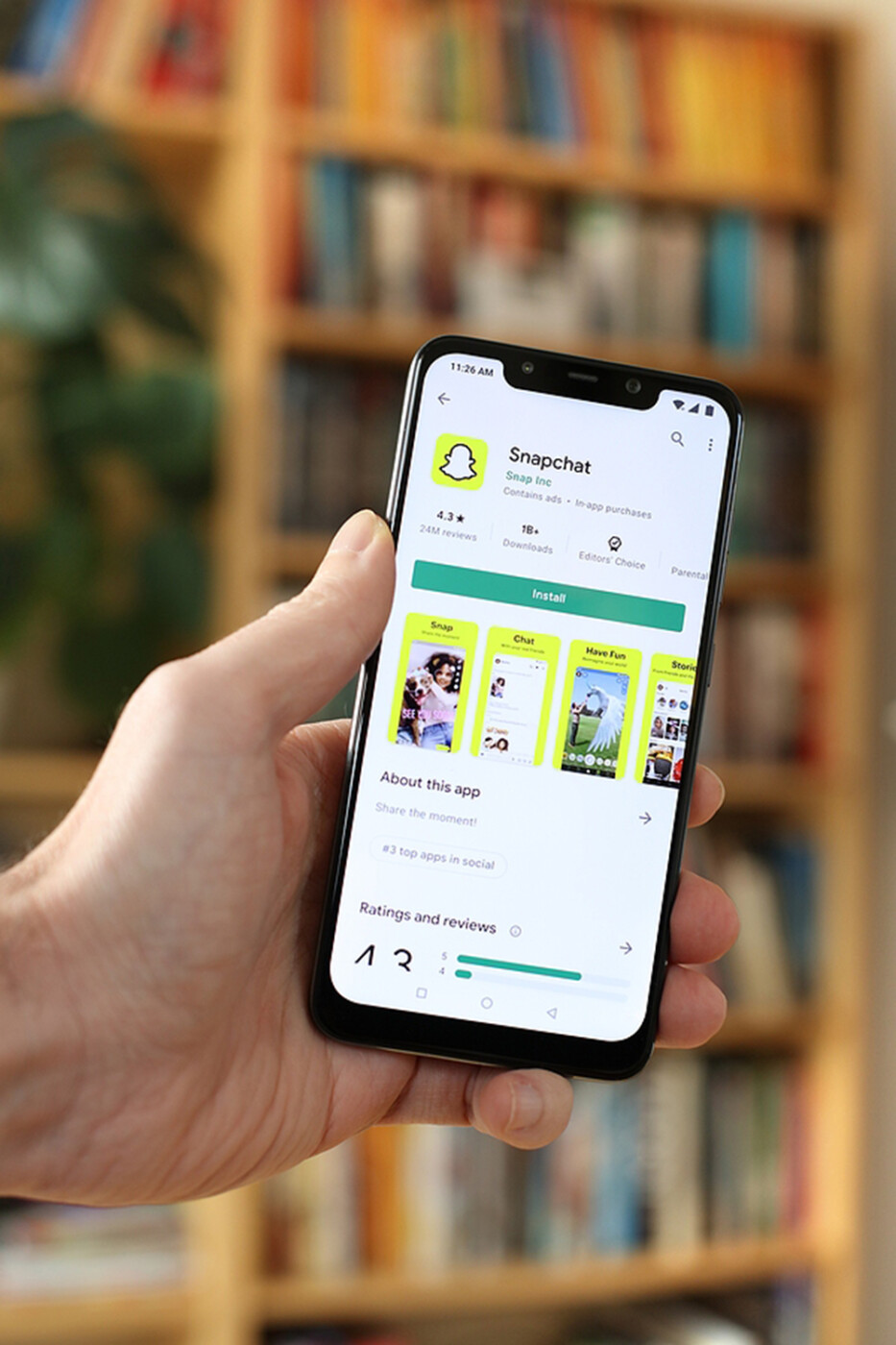 a person holding a phone looks at the snapchat app.