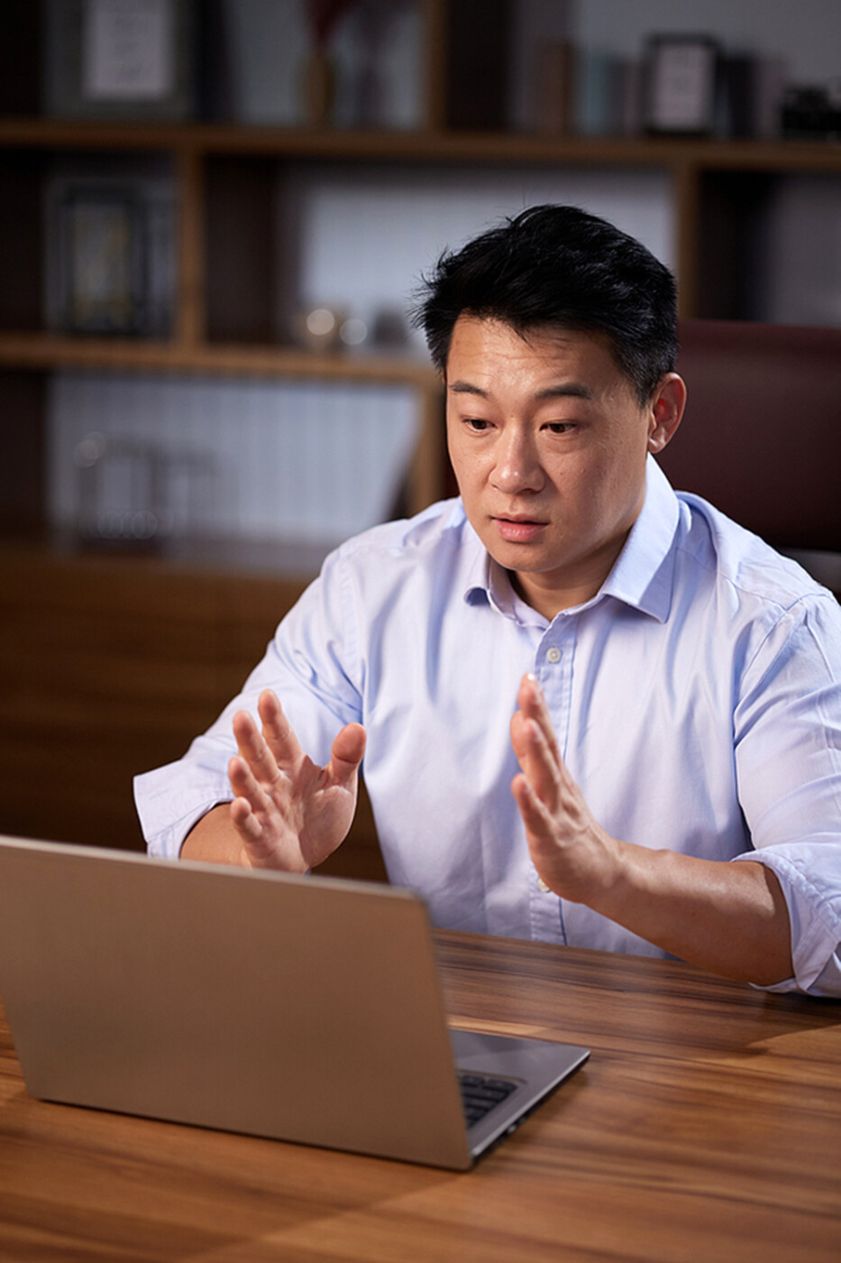 a man talks in the direction of his laptop as they conduct a webinar.