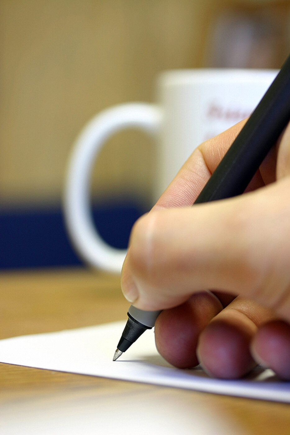 a person writes using pen on paper.