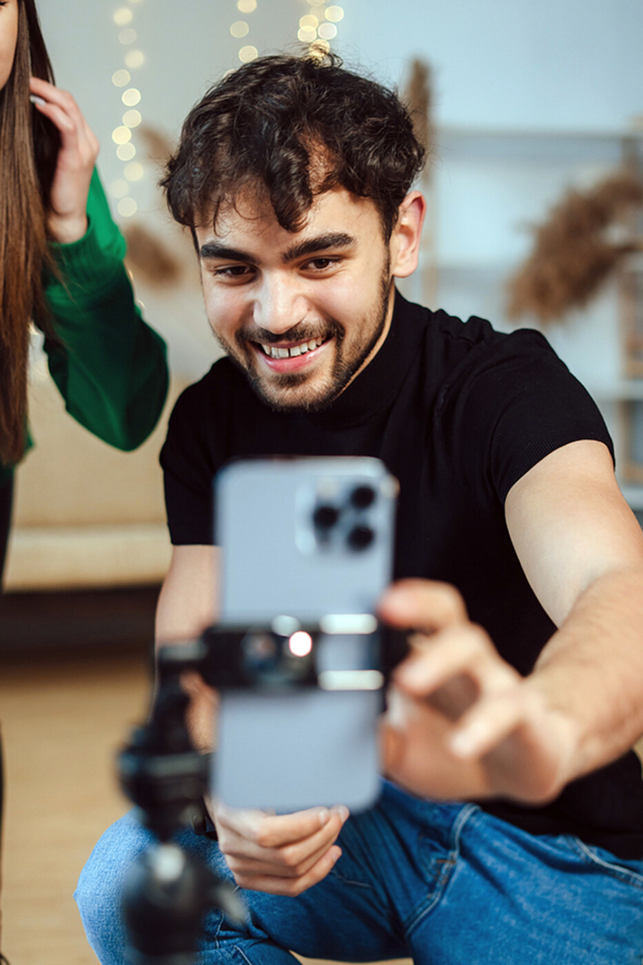 a person adjusts his iPhone which is attached to a camera stand.