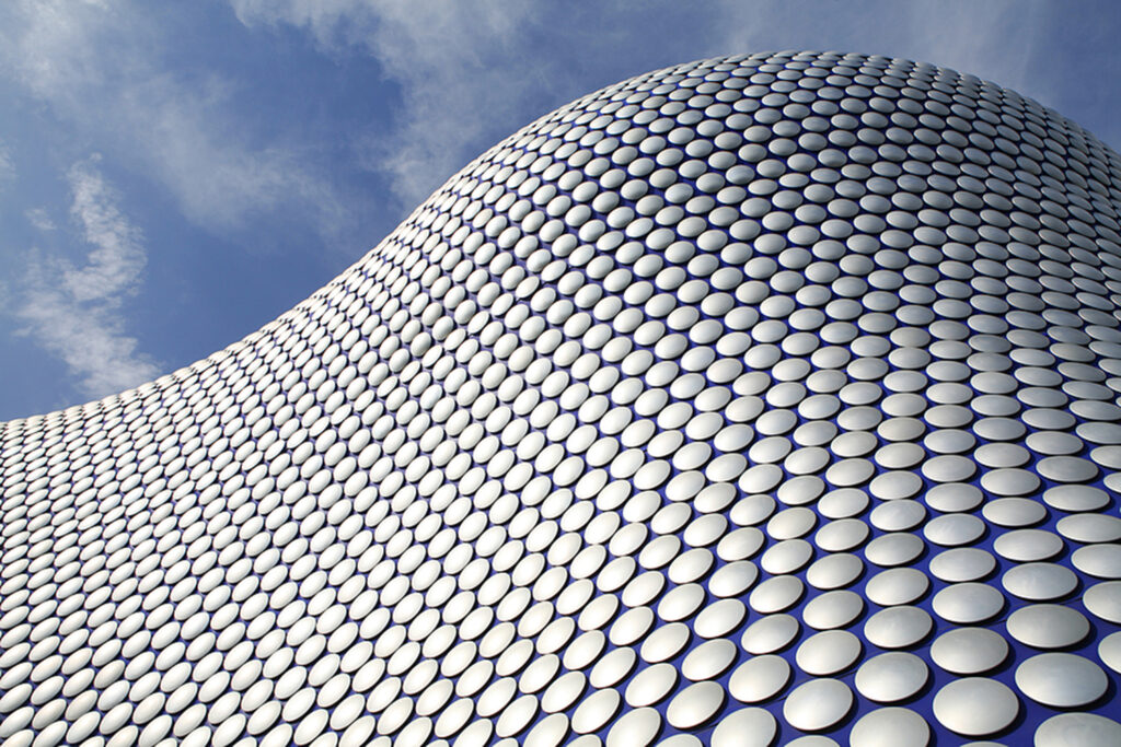 a wavy building that looks like it's built from white round studs.