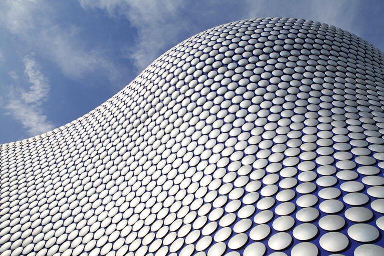 a wavy building that looks like it's built from white round studs.