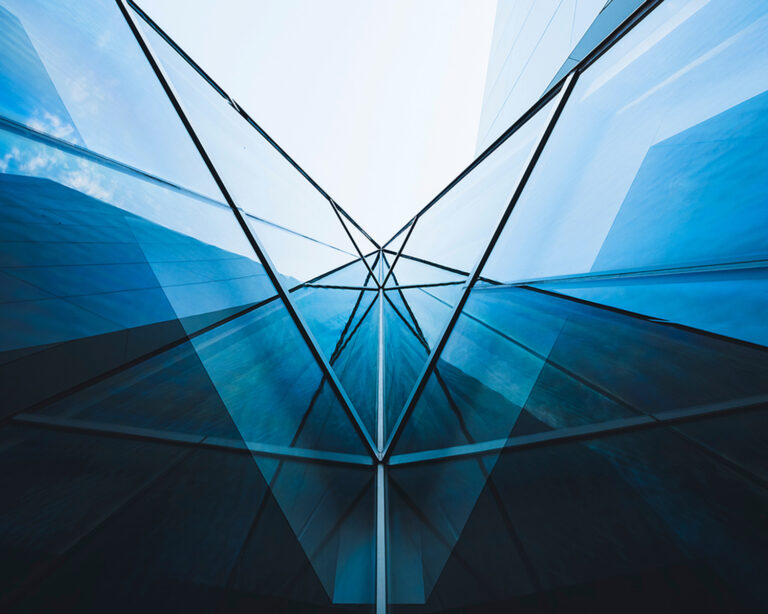 a ground-up vertical shot of a recessed corner in a glass building.