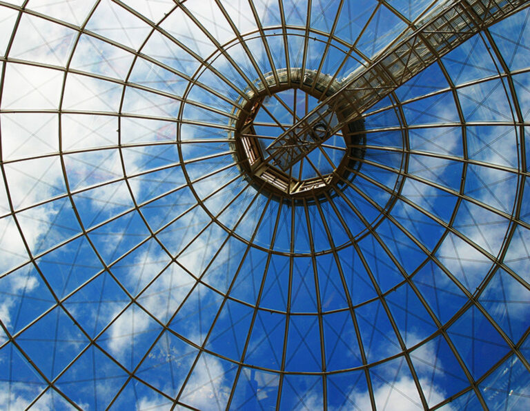 Glass architecture against a blue, partly cloudy sky.